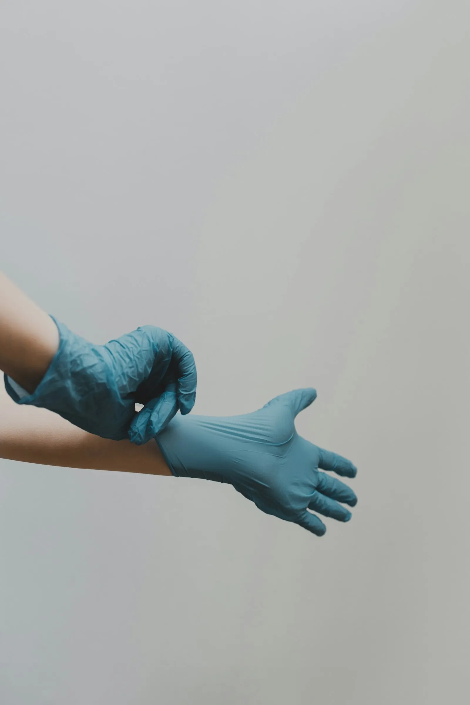 Hände in blauen Reinigungshandschuhen